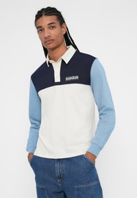 Pánská polo košile s dlouhým rukávem ve slonové kosti, námořnické modři a světle modré. Má límec, kontrastní barvy a logo na hrudi.