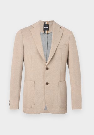 Blazer beige da uomo con rever a intaglio, due tasche applicate anteriori, due bottoni marroni e una etichetta nera con marchio all'interno del collo.