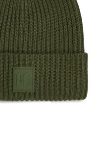 Roheline kootud müts ribakoe ja volditud äärega, mille esiosas on ristkülikukujuline roheline kummist logotahvel.