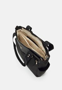 Musta olkalaukku, jossa on sileä ulkopinta, vetoketjullinen suljenta, kaksinkertaiset kahvat ja kuvioitu beige sisäpuoli, jossa useita osastoja.