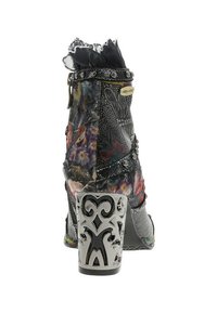 Bottine noire à fleurs avec des sangles studées, un bord en dentelle et un talon bloc argenté présentant des motifs découpés complexes.