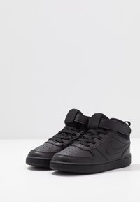 Svarta hög-top sneakers med en slät läderöverdel, perforerad tå, snörning och kardborreband. Har en texturerad panel och gummisulor.