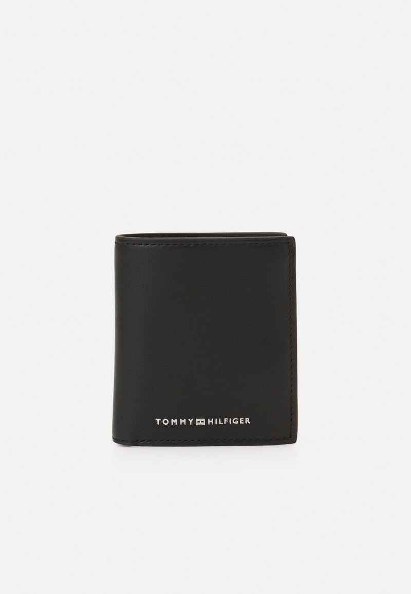 Crni kožni novčanik jednostavnog preklopnog dizajna. Sadrži urezani "TOMMY HILFIGER" logo u srebrnoj boji na dnu. Glatka tekstura, minimalistički stil.