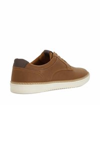 Brown leather sneaker with a smooth finish, white rubber sole, contrasting brown heel cap, and subtle stitching details. Standard lace-up design.