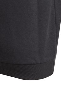 Sudadera de algodón negra con dobladillo y puños acanalados, con una textura suave y un diseño sencillo sin patrones ni adornos.