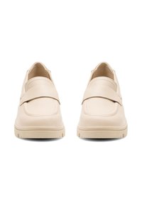 Pár béžových slip-on mokasín s širokým pásikom cez vrch a textúrovanými gumovými podošvami, zobrazené zpredu.