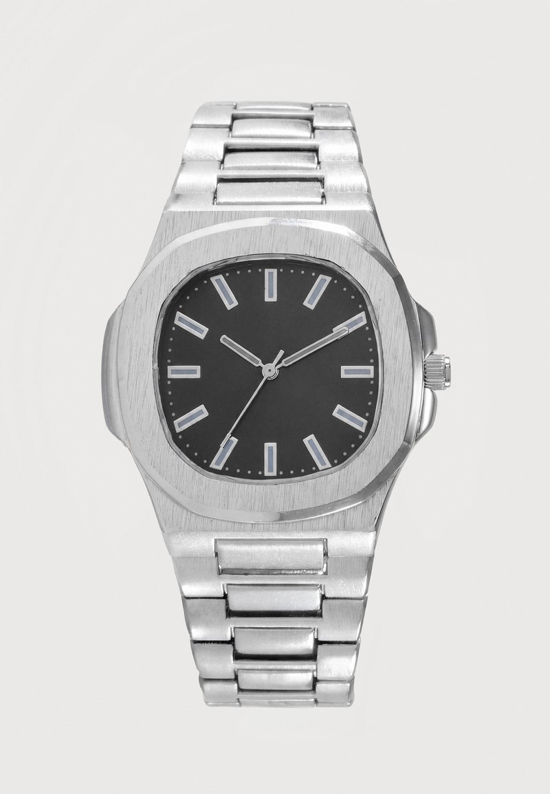 Montre-bracelet en métal argenté avec cadran noir, index rectangulaires des heures, trois aiguilles indiquant 10:10:35, et bracelet à maillons.