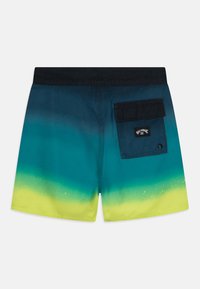 Costumi da bagno blu e verdi con un design ombre, vita nera e una tasca posteriore con pattina e etichetta sul lato destro.