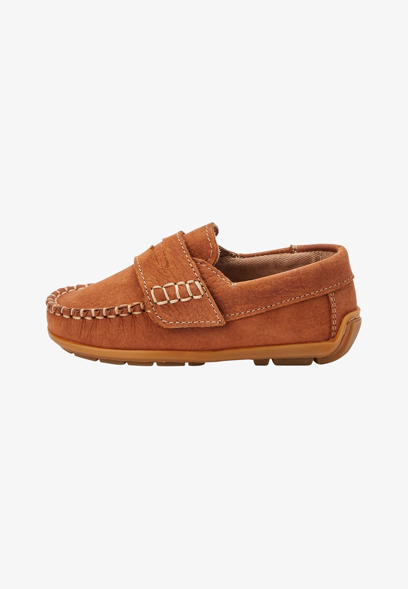 Bruine suède loafer met mocassin-stiksels, klittenbandsluiting bovenop en rubberen zool, vanaf de zijkant bekeken op een witte achtergrond.