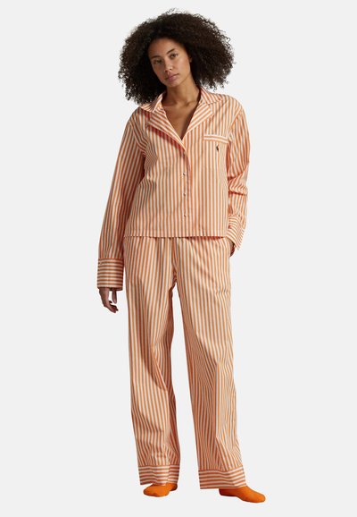 Pomarańczowo-białe paskowane piżamy z lekkiego materiału; obejmują koszulę na guziki i dopasowane spodnie z mankietami.