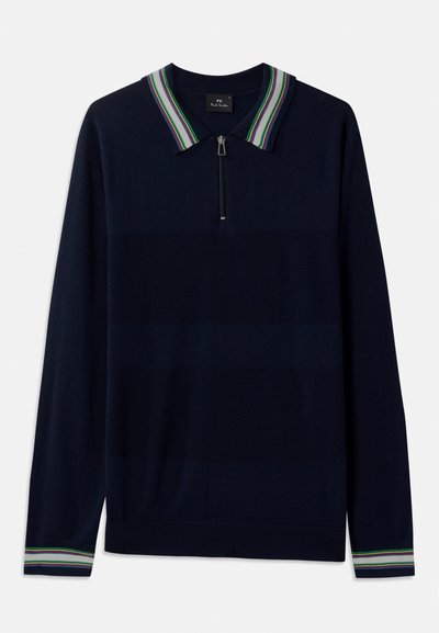 Tumed sinise pikendusega poloshirt, millel on pool-zip kaelus ja triibuline krae roheliste, valgete ja lillade detailidega. Pehme kudumise tekstuur.