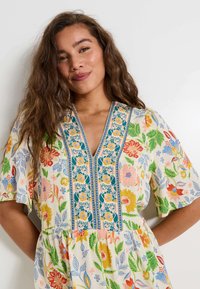 Vestido de estampado floral con escote en V, mangas cortas y bordado colorido en el corsé. Fabricado con tela ligera y acabado texturizado.