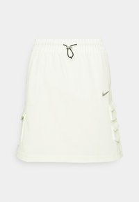 Biała, krótka, lekká spódnica Nike dla kobiet z elastycznym pasem, czarnym troczkiem i falbaniastymi bocznymi kieszeniami dla dodatkowego akcentu.