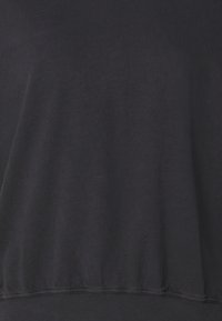 Sudadera gris oscuro hecha de suave tela de algodón, con un corte holgado y dobladillo acanalado. Textura lisa sin patrones ni acentos visibles.