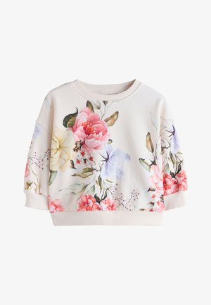 Fehér hosszú ujjú pulóver bordázott gallérral és mandzsettákkal, élénk virágmintával rózsaszín, sárga, lila és zöld árnyalatokban.