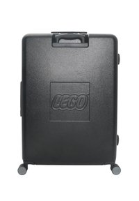 Svart hårdskalväska med strukturerad yta, LEGO-logotyp präglad fram, två hjul och ett ovansidan handtag för lätt transport.