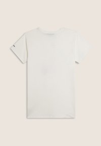 Camiseta de algodón blanca con cuello redondo y mangas cortas. Presenta un pequeño logo negro en la manga. Textura suave, diseño casual.