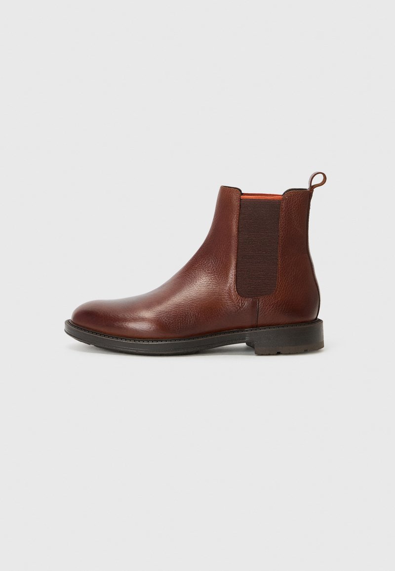 Bruine leren Chelsea-boot met elastsiche zijpanelen en een trekband. Heeft een gladde afwerking en een rubberen zool. Klassiek enkelhoogte ontwerp.