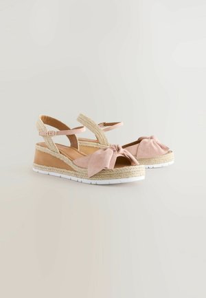Rosa Wildleder-Espadrilles mit einem geknoteten Schleifendetail, Jute-umwickeltem Keilabsatz und weißer Gummisohle. Verstellbares Fesselband für eine optimale Passform.