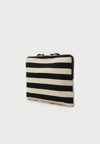 Kopertówka w paski z wyraźnymi czarnymi i beżowymi pasami, zapięcie na zamek i teksturowany materiał. Kompaktowy, prostokątny kształt z akcentami.
