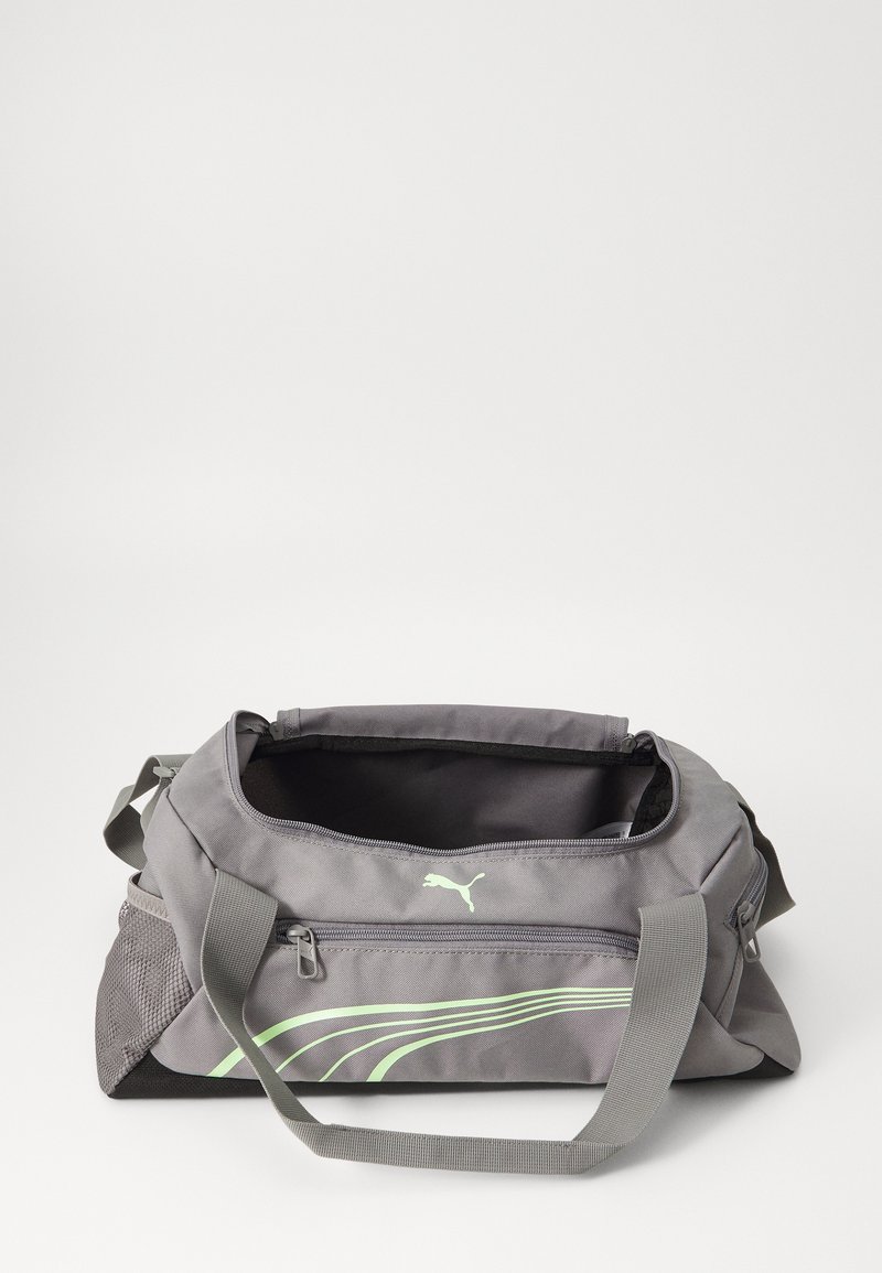 Graue Reisetasche mit strukturiertem Oberflächen, ausgestattet mit grünen Akzentstreifen und einem Logo. Mit Reißverschluss und verstellbarem Schultergurt.