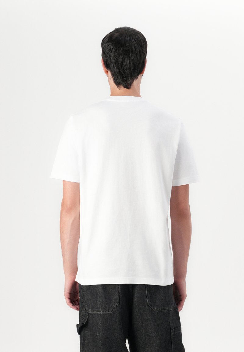 T-shirt bianco a maniche corte con collo girocolo, realizzato in cotone morbido. Il retro presenta una superficie liscia e uniforme, senza loghi o dettagli visibili.