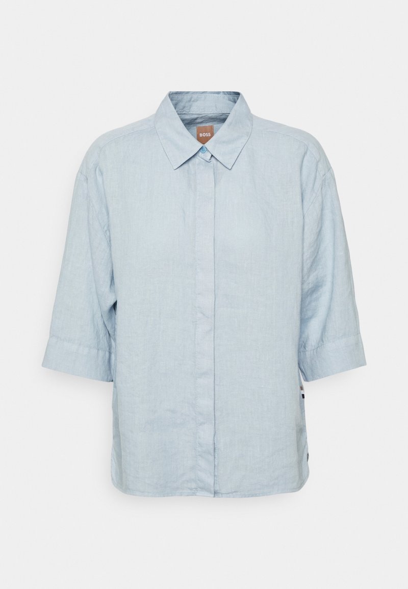 Camicia azzurra a maniche corte in lino con chiusura a bottoni, colletto classico e etichetta logo discreta di lato.