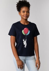 T-shirt en coton marine avec un motif représentant un astronaute tenant des ballons colorés sur fond étoilé. Col rond et manches courtes.