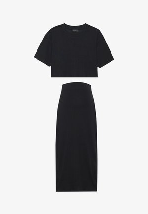 Črn rebrast crop top s kratkimi rokavi in ujemajoča midi krila. Obe krpi imata prilegajočo zasnovo in mehak tekstur.