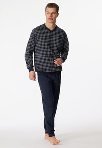 Navy and beige checkered long-sleeve top with V-neck, paired with solid navy jogger pants. Both items feature soft fabric and elastic cuffs.