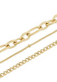 Catene d'oro di diversi design: una a maglia ovale spessa, una sottile con texture e una a maglie standard. Tutte presentano una finitura lucida.