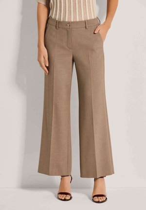 Bruine wijde broek van een gestructureerde stof, met een knoopsluiting en zijzakken, gecombineerd met hakken met bandjes.