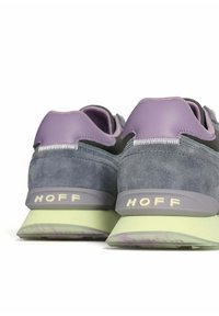 Zapatillas deportivas de ante gris con acentos en lavanda. Presentan un panel trasero texturizado, un cuello acolchado y suelas de color verde claro.