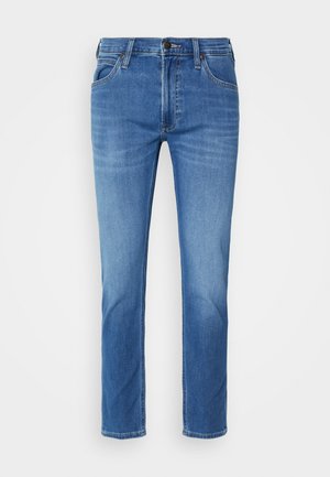 Pantalones vaqueros de mezclilla azul con corte recto, cinco bolsillos, costuras visibles y cierre de botón. Textura suave con un acabado de lavado medio.