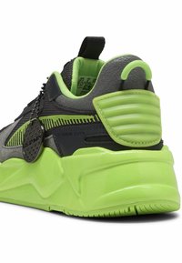 Baskets chunky avec une tige synthétique noire et grise, accents vert fluo, talon texturé et semelle verte brillante. Comprend une étiquette décorative.
