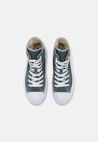 Sneakers înalte din pânză verde închis, cu vârf și talpă din cauciuc alb, având șireturi și detalii de cusătură albe.