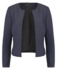 Veste courte bleu marine à manches longues, devant ouvert, doublure intérieure noire et poches zippées des deux côtés.