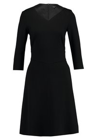 Robe noire longueur genou avec manches trois-quarts, taille cintrée et décolleté en V avec fermeture éclair dans le dos.