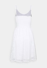 White dress with a fitted bodice and flared skirt, made of lace with floral patterns. Features adjustable straps and a smooth lining.