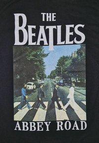 Svart T-skjorte med "THE BEATLES" i hvit tekst over en fargerik illustrasjon av Abbey Road-albumet med fire figurer som krysser en vei.