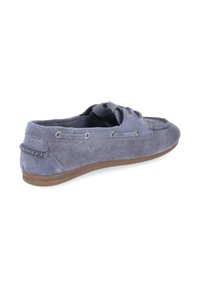 Mocassin en daim gris unique avec détails en lacets, semelle en caoutchouc et accents cousus, montré de côté sur fond blanc.