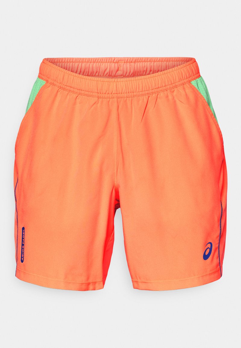 Orange sportshorts med en strækbar talje. Har grønne netindsatser på siden. Inkluderer et blåt logo og sorte syninger.