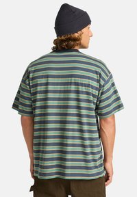 Striped short-sleeve t-shirt featuring blue, green, and yellow horizontal stripes. Made of lightweight material with a relaxed fit and round neckline.