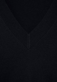 Gros plan d'un pull en laine noir à col en V montrant l'encolure côtelée et la texture fine du tricot.