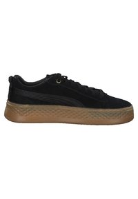 Baskets basses noires avec semelle marron texturée, laçage à l'avant et détail subtil d'une bande latérale, vues de profil extérieur.
