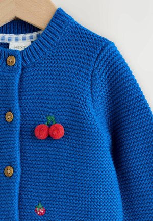 Niebieski sweter rozpinany na drewniane guziki, ozdobiony aplikacjami wiśni z czerwonego filcu i zielonym haftem. Materiał o fakturze, z prążkowanym kołnierzem.