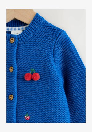 Cardigan bleu tricoté avec des boutons en bois, orné d'appliques de cerises en feutre rouge et broderies vertes. Tissu texturé avec col côtelé.