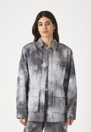Šedá farba s vzorom tie-dye, bunda s golierom, veľkými náprsními vreckami a priamym strihom. Vyrobená z tkaniny s hladkým povrchom a jemnými detailmi šitia.