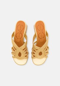 Sandale aurii împletite cu un design cu decupaj oval, curele țesute texturate și o talpă aurie netedă. Insole maro cu branding.