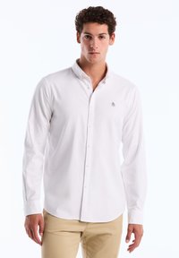 Witte button-up shirt van katoen met lange mouwen, met een klein marineblauw logo op de borst en een klassiek kraagontwerp.